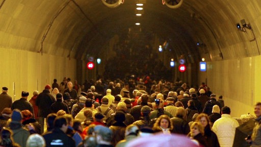 Menschen laufen durch den Wesertunnel
