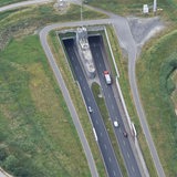 Die Luftaufnahme zeigt wie ein LKW und Autos, bei Dedesdorf in den Wesertunnel fahren.
