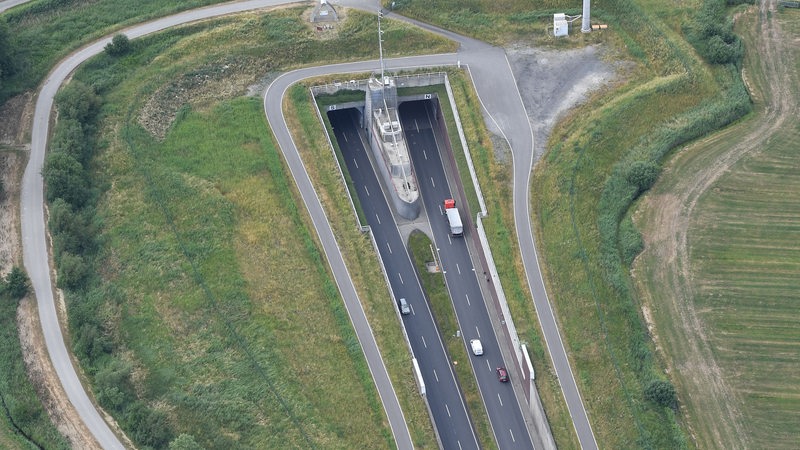 Die Luftaufnahme zeigt wie ein LKW und Autos, bei Dedesdorf in den Wesertunnel fahren.