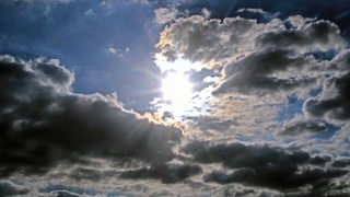 Zwischen Wolkenlücken scheint die Sonne durch.