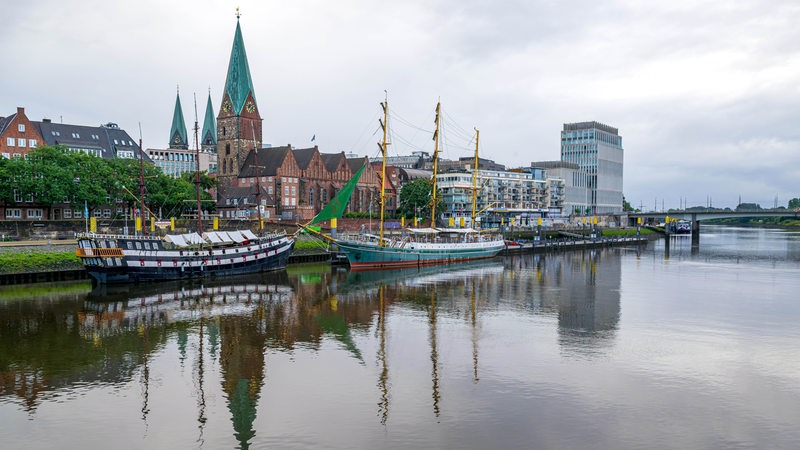 An der Schlachte liegen Schiffe. Am Himmel sind Regenwolken zu sehen.