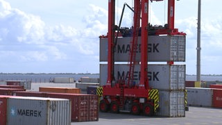 Der Jade Weser Port mit mehreren Container und einem Containerstapler.