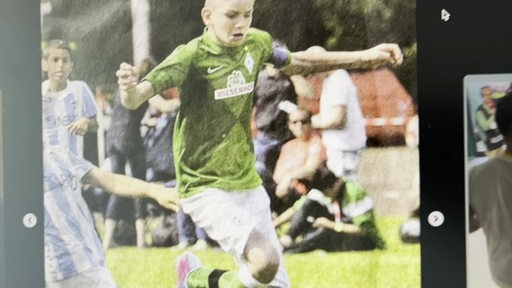 Der junge Nick Woltemade im grünen Werder Trickot beim Fußball spielen.