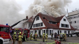 Feuerwehrleute löschen ein Haus