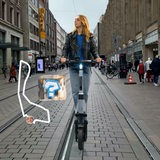 Eine junge Frau fährt auf einem E-Scooter durch eine Einkaufsstraße.