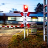Zug passiert geschlossene Schranken