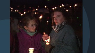 Zwei junge Frauen mit Teelichtern auf dem " Lichterkette gegen Ausländerhass und Rassismus" Protest in Bremen.