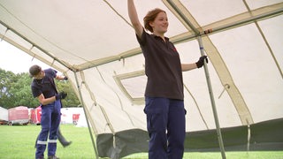 Ein Mädchen hilft beim Aufstellen eines Zeltes