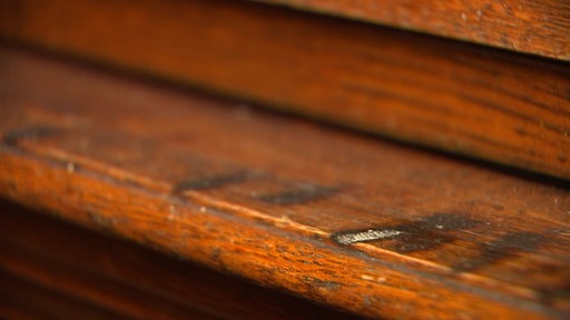 Zu sehen sind die dunklen Spuren einer Zigarre im Holz im Gerichtssaal 