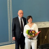 Innensenator Ulrich Mäurer und Ute Kraft-Uhlhorn posieren für die Fotografen, sie trägt einen Blumenstrauß