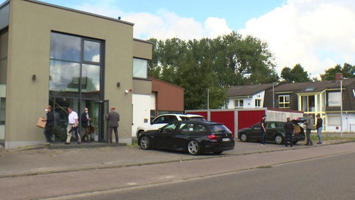 Beamten vom Zoll durchsuchen eine Firma in Lilienthal und tragen Akten aus dem Gebäude. 
