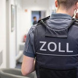 Ein Zollbeamter steht im Flur eines Bürogebäudes.