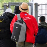 Geflüchtete betreten neben einem Schild vom Bundesamt für Migration und Flüchtlinge die Landesaufnahmebehörde Niedersachsen