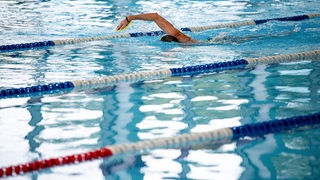 Ein Schwimmer zieht durch eine Bahn im Horner Bad. 