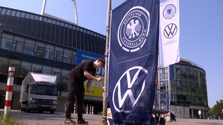Vor dem Bremer Weser-Stadion hisst ein Mann die blaue Flagge des Deutschen Fußball-Bundes vor dem Länderspiel in Bremen.