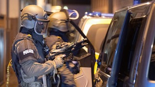 Zwei Polizisten eines Spezialeinsatzkommandos mit Helmen, Maske und Waffen
