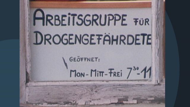 Auf einm Schild steht geschrieben: "Arbeitsgruppe für Drogengefährdete".