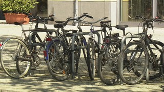 Es sind mehrere Fahrräder an Fahrradständern angeschlossen. 