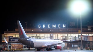Ein Flugzeug steht nachts auf dem Rollfeld vom Flughafen Bremen.