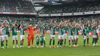 Die Werder-Spieler stehen aufgereiht vor der Ostkurve im Weser-Stadion und feiern mit den Fans das Saisonfinale.