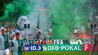 Bremer Ultras zünden Pyrotechnik und grün-weiße Rauchpfannen während Werders Pokal-Spiel bei Viktoria Köln.