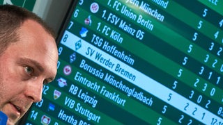Werder-Trainer Ole Werner bei einer Pressekonferenz nur als Kopf sehen, hinter ihm ein großer Bildschirm mit der Bundesliga-Tabelle.