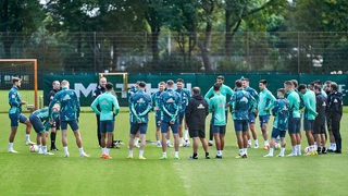 Die Werder-Spieler bilden einen Mannschaftskreis.
