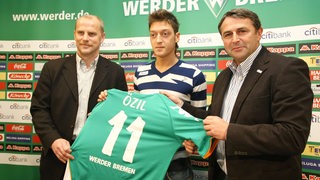 Mesut Özil bei seiner Präsentation bei Werder neben Schaaf und Allofs und mit seinem Trikot mit der Nummer 11.