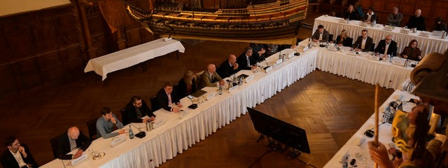 Die Teilnehmer des Innenstadt-Gipfels sitzen an einem Tisch.