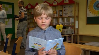 Ein Kind liest aus einem Kinderbuch.