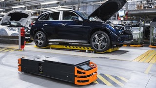 Autoproduktion in Halle 9 im Bremer Mercedes-Werk. Im Hintergrund ein dunkelblauer Wagen.