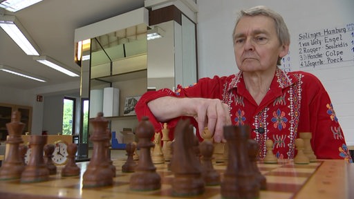 Peter Orantek, Förderer des SK Kirchweyhe, sitzt vor einem Schachbrett.