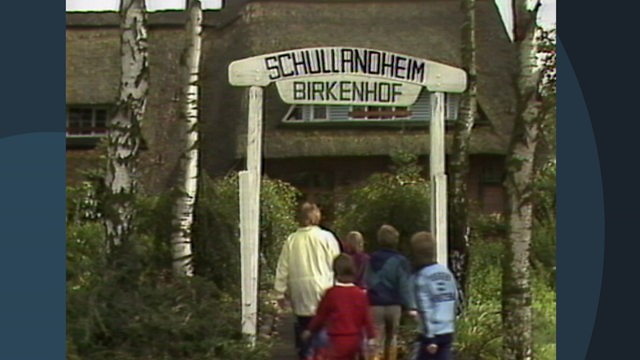 Mehrer Kinder laufen unter dem Schild "Schullandheim Birkenhof" hindurch.