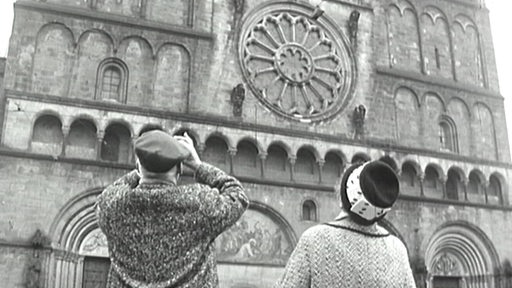Ein schwarz-weiß Bild, das zwei ältere Personen beim Sightseeing in Bremen zeigt.