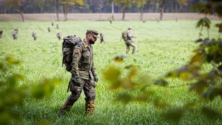 Soldaten der Bundeswehr suchen ein Feld ab. 