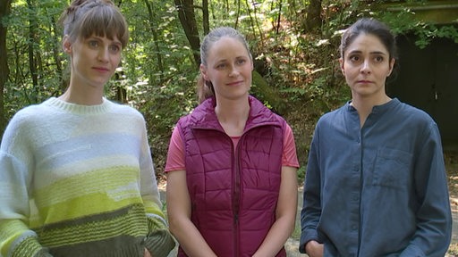 Drei Schauspielerinnen stehen in einem Wald bei den Dreharbeiten für den Tatort.