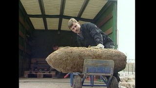 Eine Weltkriegsbombe wird geborgen und von einem Mann in einen Laster verladen.